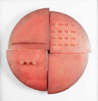 Red circular glass sculpture that hangs on wall